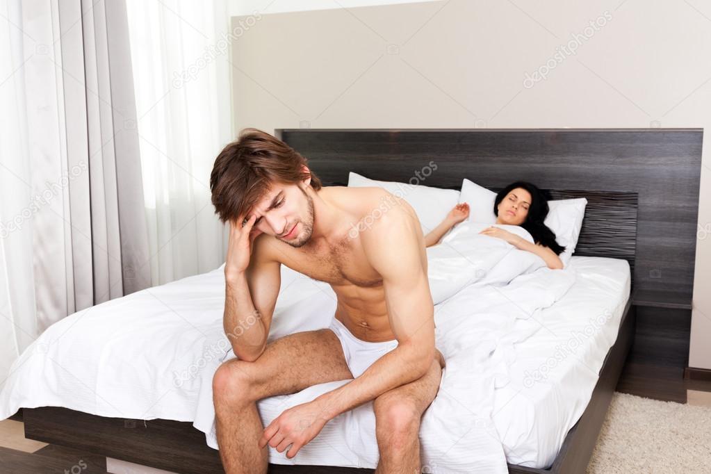 Unhappy separate couple lying in a bed