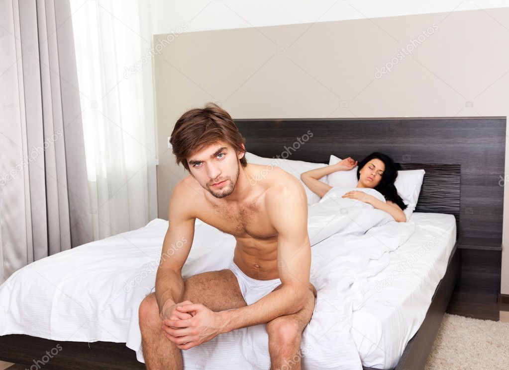 Unhappy separate couple lying in a bed