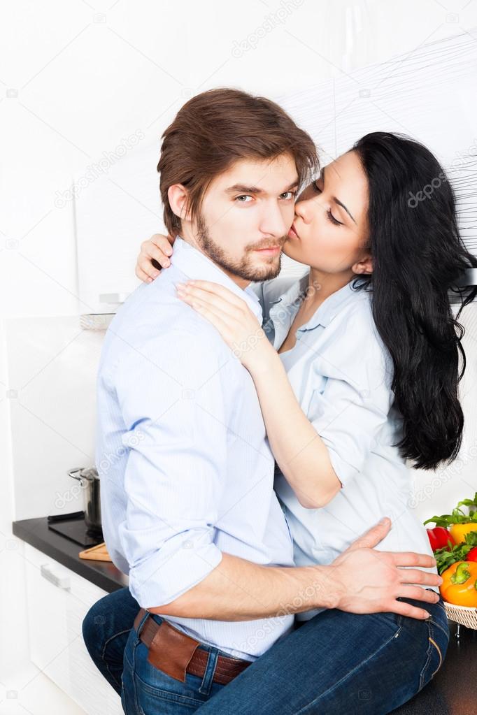 Couple kissing at their kitchen