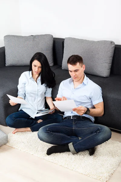 Pareja infeliz leyendo una carta en la sala de estar — Foto de Stock