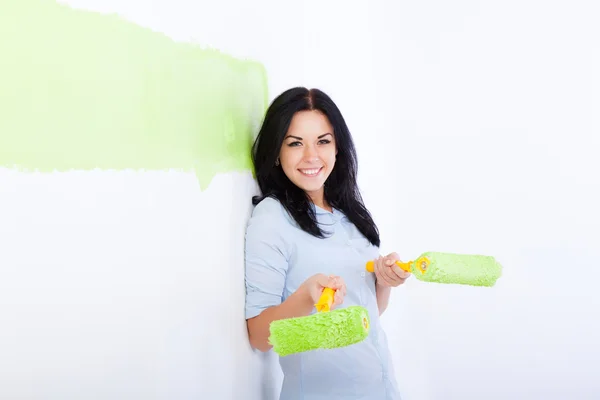 Mujer sonrisa pintura en color verde hogar pared blanca — Foto de Stock