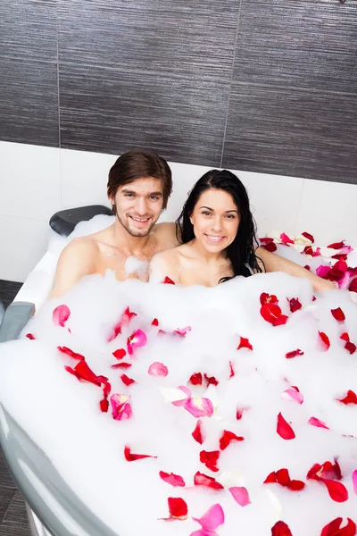 Jovem casal feliz deitado em jacuzzi — Fotografia de Stock