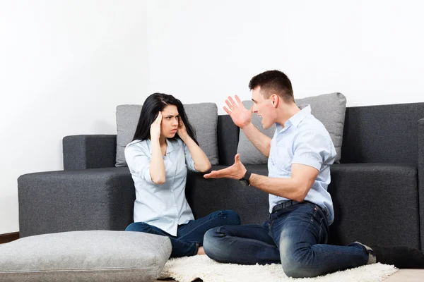 Couple conflict sitting on floor at living room — Stock Photo, Image