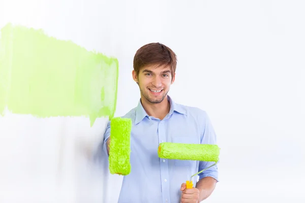 Άνθρωπος χρώμα σε πράσινο χρώμα σπίτι λευκό τοίχο — Φωτογραφία Αρχείου