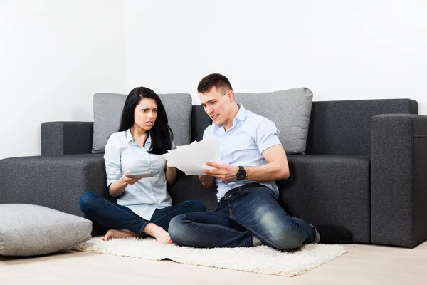 Unglückliches Paar liest Brief im Wohnzimmer — Stockfoto
