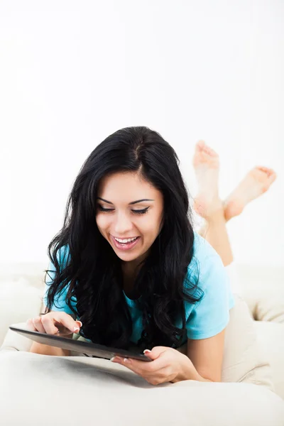 Mujer con la tableta acostada en el sofá —  Fotos de Stock