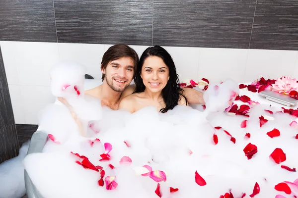 Young happy couple lying in jacuzzi — Stock Photo, Image