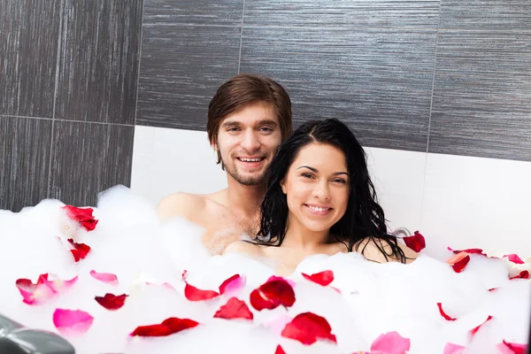 Jovem casal feliz deitado em jacuzzi — Fotografia de Stock