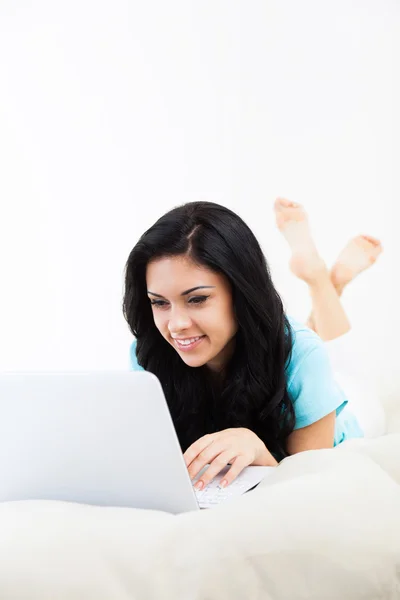 Belle femme avec ordinateur couché sur canapé à la maison surf — Photo