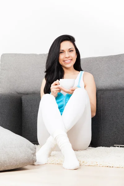 Woman hold cup of coffee sitting on floor — Stock Photo, Image