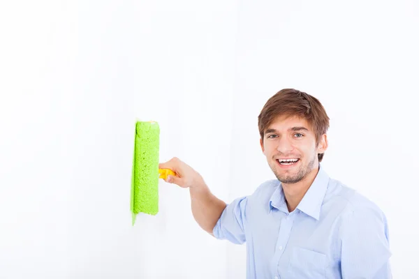 Man paint in green color white wall — Stok fotoğraf