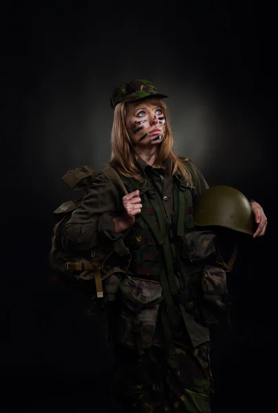 Hermosa chica del ejército celebrar mochila y casco — Foto de Stock