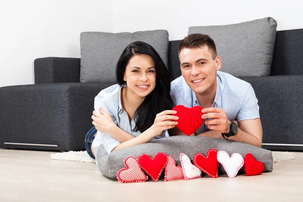 Couple holding lot of red valentine's heart — Stock Photo, Image