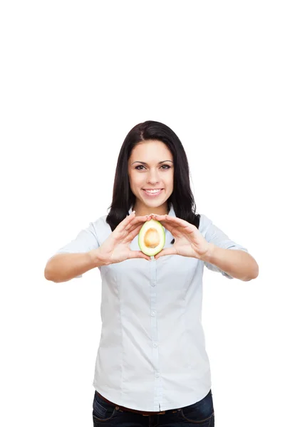 Junge Frau hält grüne frische rohe Avocado in der Hand — Stockfoto