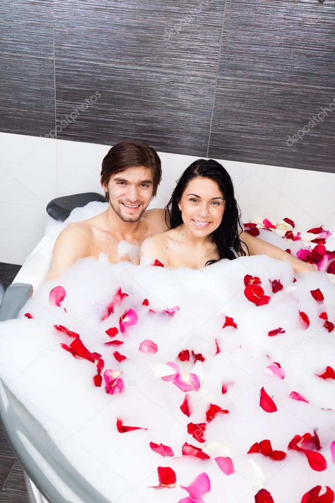 Young happy couple lying in jacuzzi