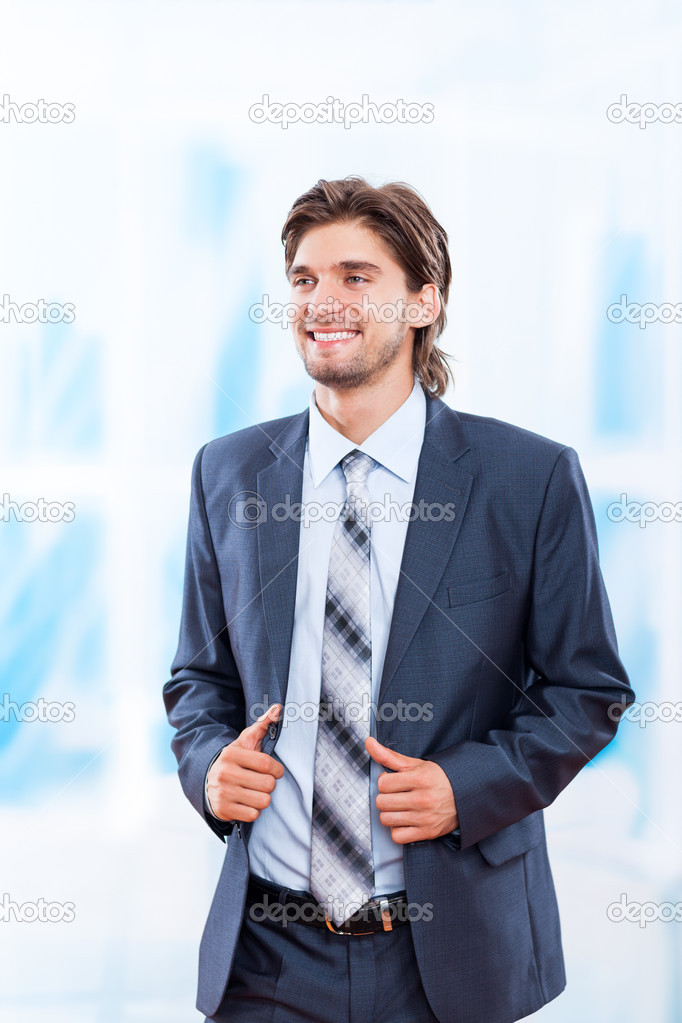 Young business man smile in bright blue office