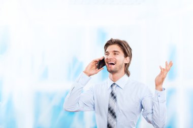 parlak mavi ofis cep telefonunda konuşan işadamı