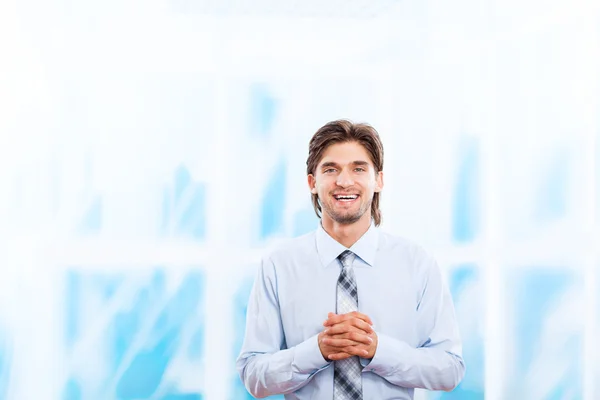 Joven hombre de negocios sonrisa en brillante oficina azul — Foto de Stock