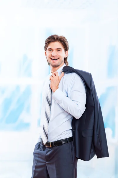 Joven hombre de negocios sonrisa en brillante oficina azul —  Fotos de Stock