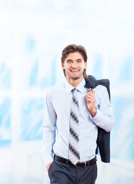 Junger Geschäftsmann lächelt in hellblauem Büro — Stockfoto