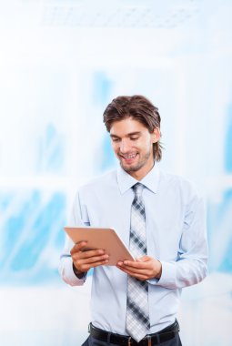 Parlak mavi ofis, dokunmatik ekran genç işadamı tablet pad bilgisayar kullanarak iş adamı