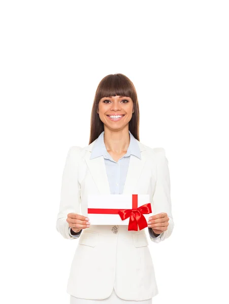 Iş kadını mutlu gülümseme tutmak hediye kart kırmızı yay ile mevcut. — Stok fotoğraf