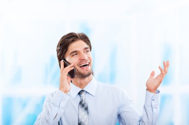 parlak mavi ofis cep telefonunda konuşan işadamı