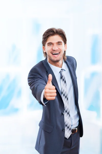 Junger Geschäftsmann hält Hand mit Daumen-hoch-Geste — Stockfoto