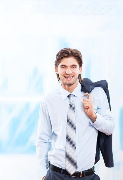 Junger Geschäftsmann lächelt in hellblauem Büro — Stockfoto