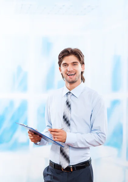 Business man with clipboard in bright blue office — Stock Photo, Image