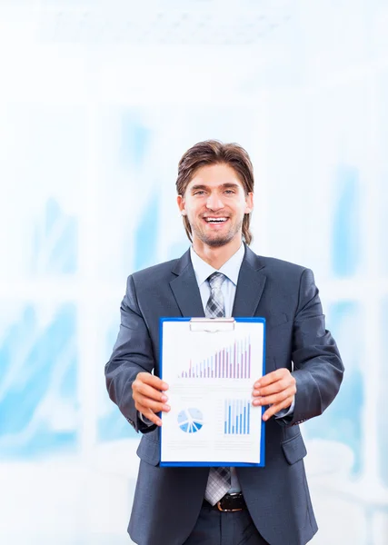 Joven hombre de negocios con sonrisa feliz mostrar diagrama o gráficos de negocios —  Fotos de Stock