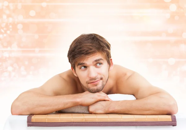 Hombre guapo acostado en la mesa de masaje —  Fotos de Stock