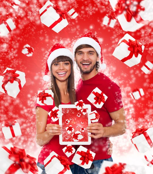 Счастливая пара на Рождество держит в руках планшетный компьютер — стоковое фото