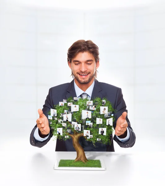 Businessman grow green tree from tablet screen — Stock Photo, Image
