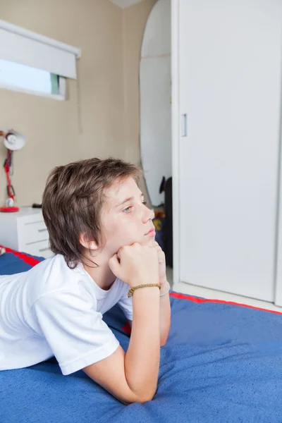 Aufgebrachter Junge liegt auf Bett — Stockfoto