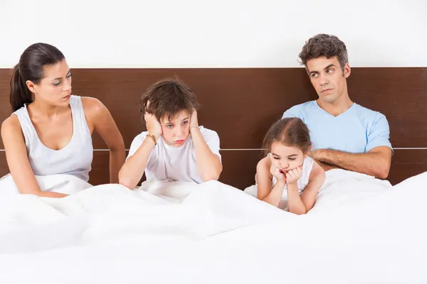 Família infeliz deitada na cama — Fotografia de Stock