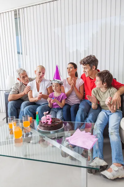 Girl blowing out candles on cake — Stock Photo, Image