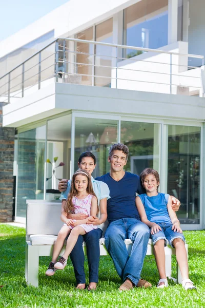 Família feliz na frente da nova casa — Fotografia de Stock