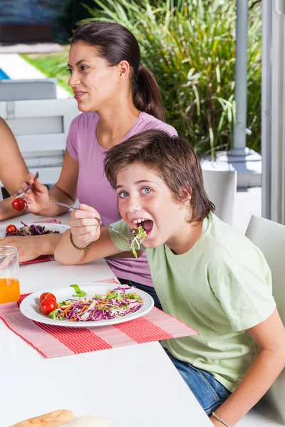 Garçon manger de la salade à la table — Photo