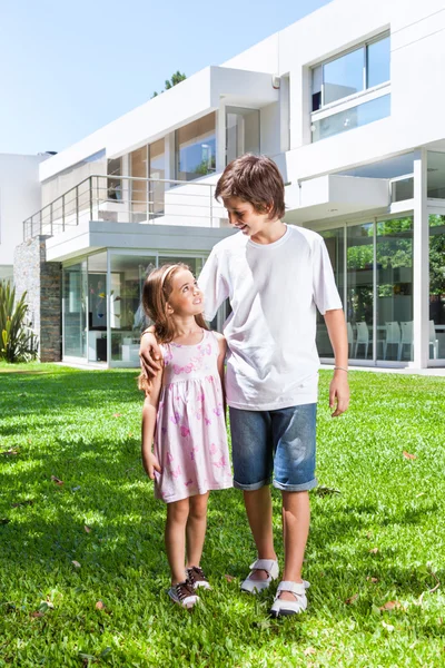 Los niños caminan fuera de casa nueva —  Fotos de Stock