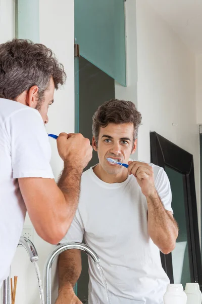 Hombre cepillarse los dientes — Foto de Stock