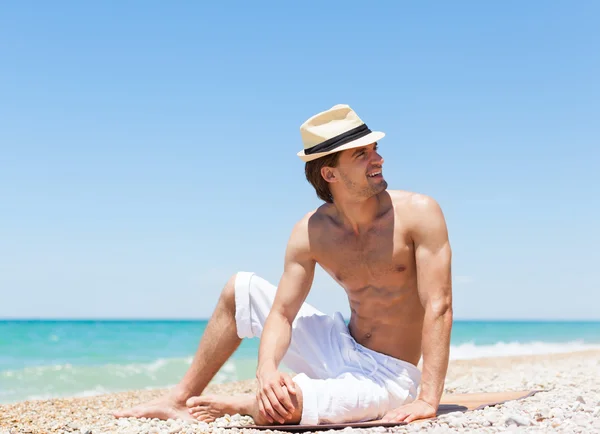 Uomo seduto sulla spiaggia — Foto Stock