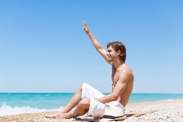 Homme assis sur la plage — Photo