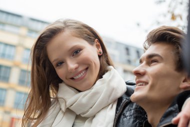 adam açık havada otururken gülümseyen kadın