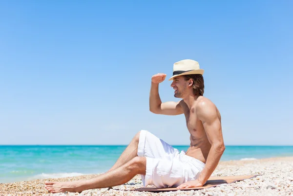 Homem sentado na praia — Fotografia de Stock