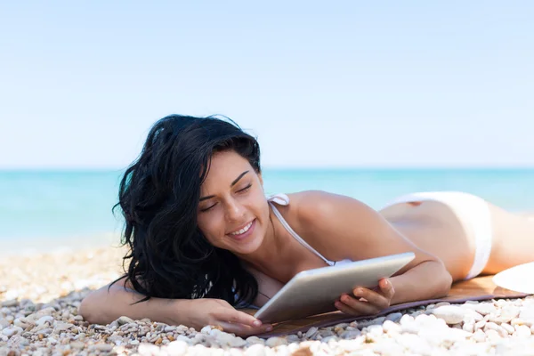 Vrouw met behulp van Tablet PC op strand — Stockfoto