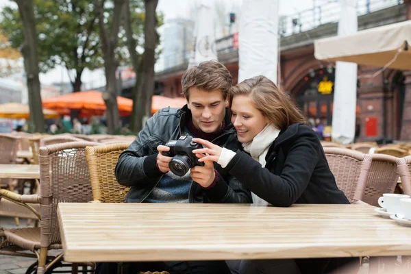 Casal olhando para a câmera digital — Fotografia de Stock