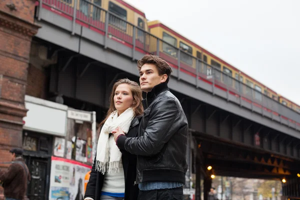 Pareja mirando hacia otro lado contra el puente del tren —  Fotos de Stock