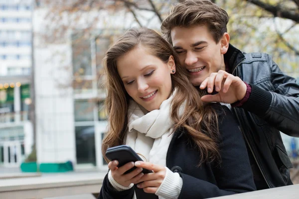 Pareja en chaquetas de invierno con teléfono móvil — Foto de Stock