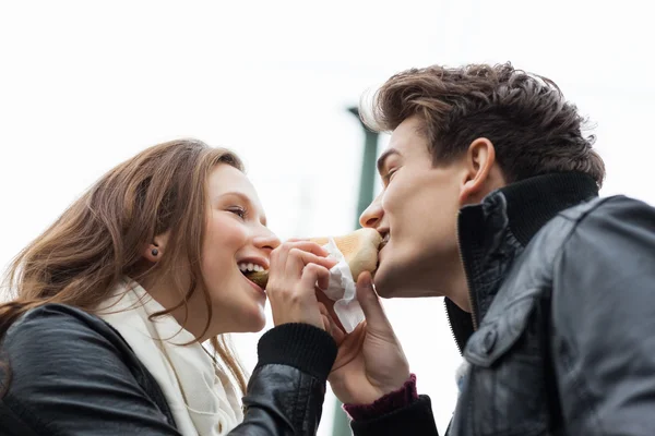 Couple Eating Hotdog Together Against Sky — Stock Photo, Image